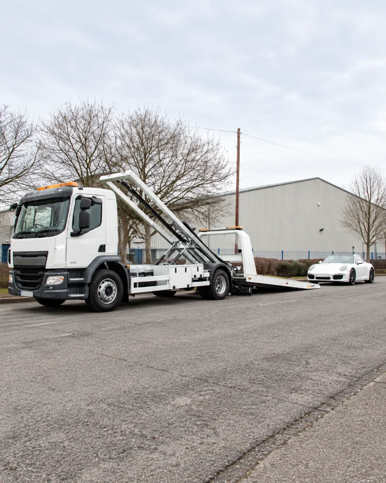 Tilt Deck truck and white sports car